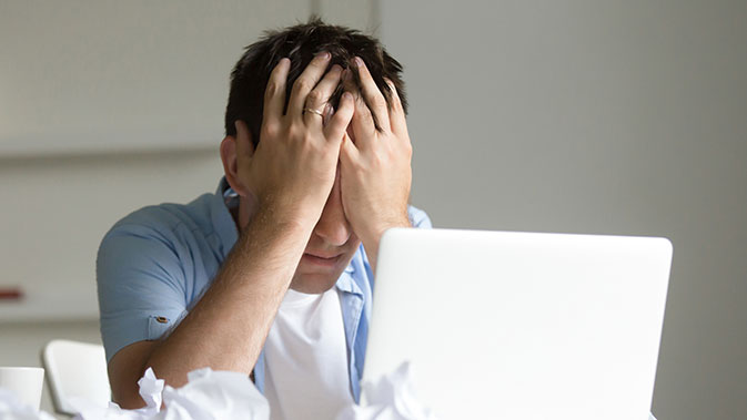 Gestresster Mann vor dem Laptop - Die Arbeit ist einer der häufigsten Gründe für Stress.