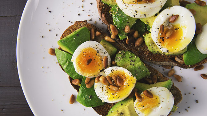 Eine Scheibe Eiweißbrot mit Ei und Avocado eignet sich bei einer ketogenen Ernährungsweise optimal als eine kleine Mahlzeit.