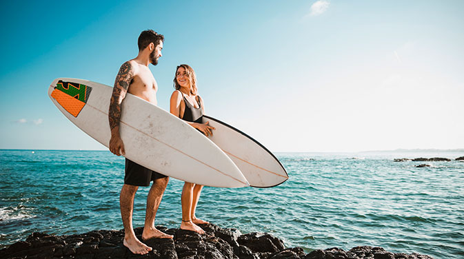 Zwei Surfer mit Surfbrettern am Meer