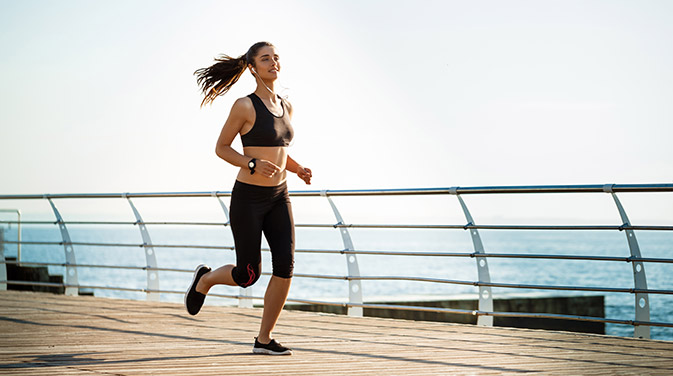 Frau joggt an der Promenade entlang