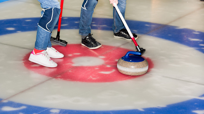 zwei Personen auf einem Curling-Feld
