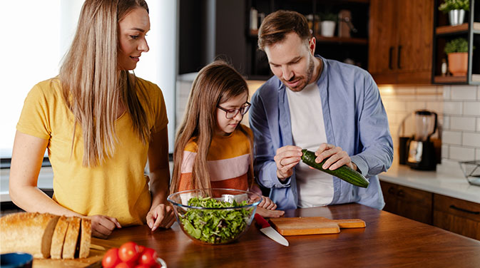 Eltern mit Kind in der Küche beim Kochen