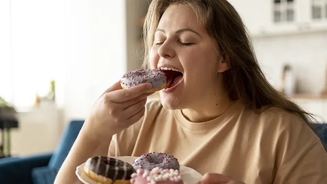 Frau beißt in einen süßen Donut.