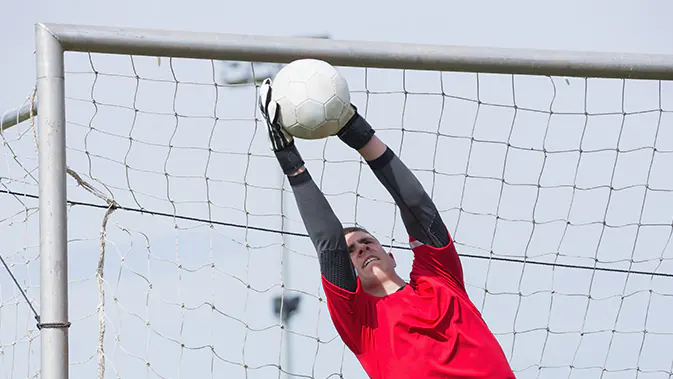 Das Krafttraining für Torhüter sieht anders aus, als das für Stürmer. Torwart im Tor springt zu einem Ball