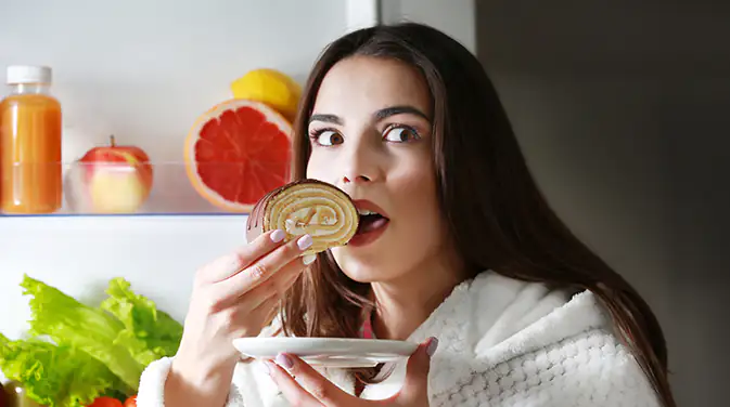 Frau isst ein Stück Kuchen