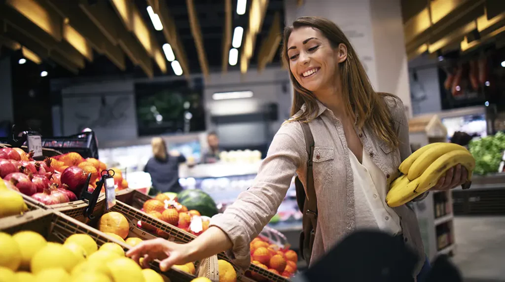 Eine Frau im Supermarkt kauft verschiedenes Obst ein