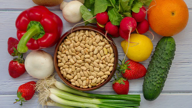 Verschiedene Lebensmittel sind abgebildet, unter anderem Paprika, Bohnen, Erdbeeren, Zitrone, Lauch und Champignons