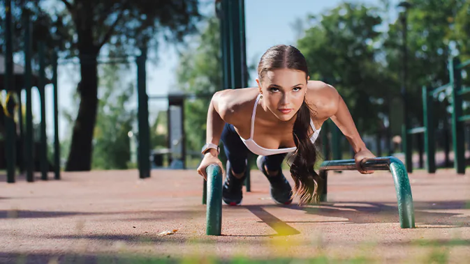 Frau, die Sport in einem Outdoor Gym macht.