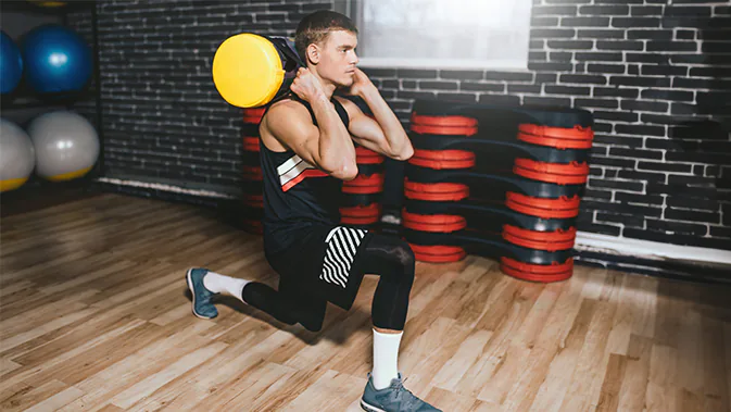 Ein Mann führt die Übung Lunges mit einer Sandbag aus