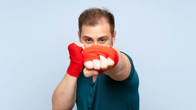 Ein Mann macht eine Punch-Pose wie beim Boxen