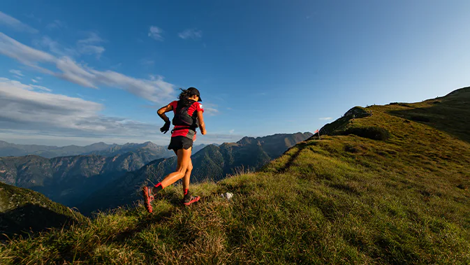 Eine Frau joggt in der Natur auf einem Berg