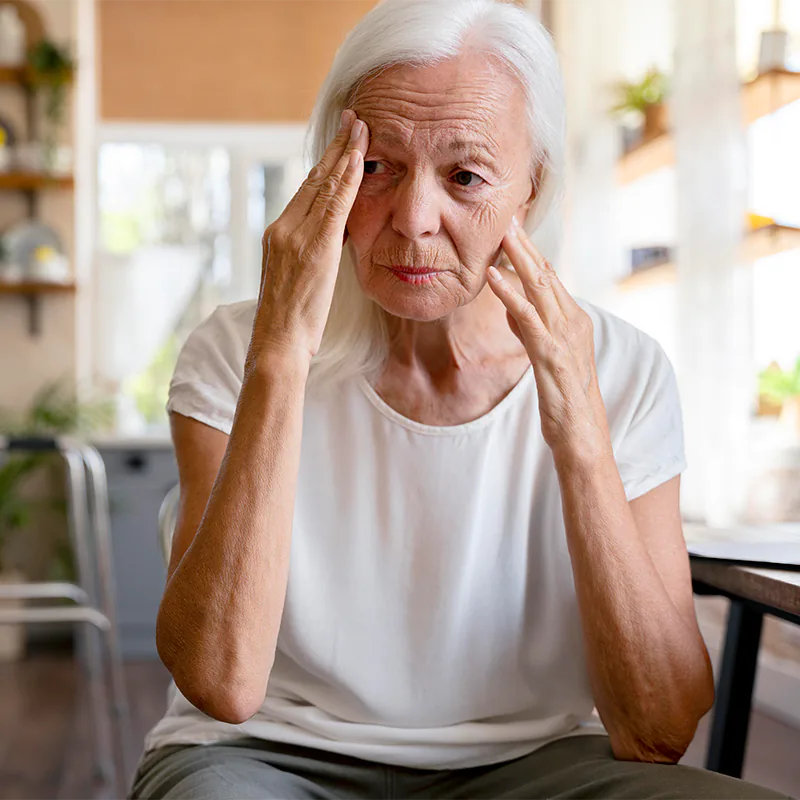 Ältere Frau guckt besorgt und fährt sich mit beiden Händen durch ihr Gesicht
