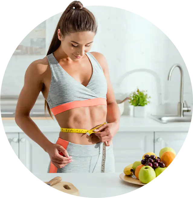 Eine Frau misst ihren Bauchumfang mit einem Maßband